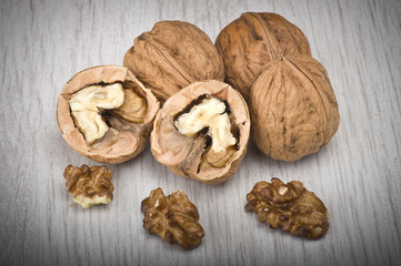 walnuts in shell and open on wood gray table