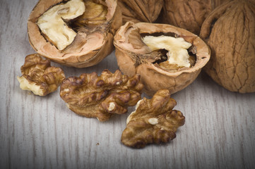 walnuts in shell and open on wood gray table