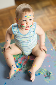 Baby messed with colorful paint