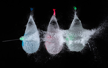 high speed photo of 3 bursting water filled balloons 
