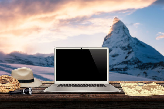 white laptop map hat rope torch on the table with winter mountains in the background mockup presentation