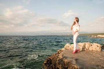 Beautiful young woman looking at the ocean.