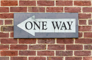 One way sign on a brick wall