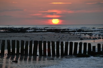 Zach&oacute;d słońca na morzu. Jasne słońce na niebie. krajobraz plaży
