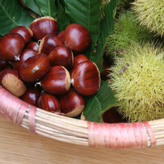 castagne in un cesto su tavolo di legno