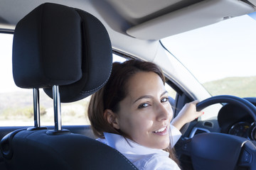 Fototapeta na wymiar Businesswoman standing smiling inside of a sports car