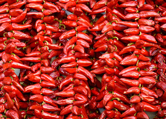 Strings of PDO Espelette chilli peppers drying