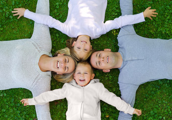 Family lying on the grass and smiling