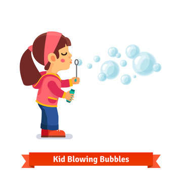 Cute little girl blowing soap bubbles through wand