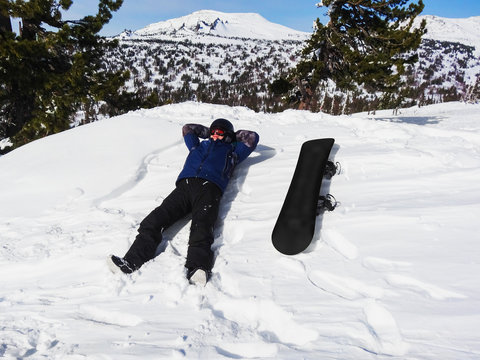 Snowboarder lying on snow