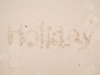 holiday written in sand on the beach