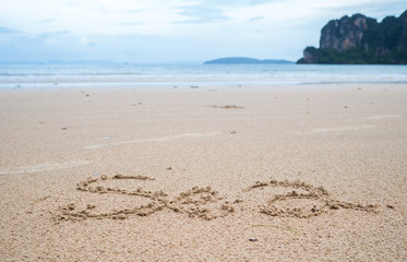 sea written in sand on the beach