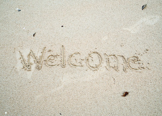 welcome written in sand on the beach