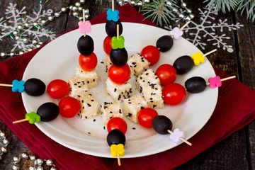 Poster Canapes with feta cheese and cherry tomatoes on a festive table © elena_hramowa