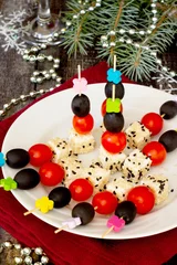 Poster Canapes with feta cheese and cherry tomatoes on a festive table © elena_hramowa