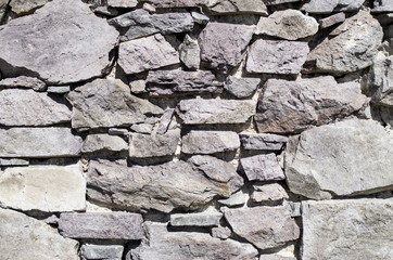 Old stone wall closeup  in sunny day