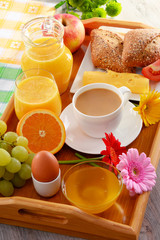 Breakfast on tray served with coffee, juice, egg, and rolls