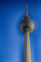 Part of a Berlin's television tower with a ball and spire against the blue cloudless sky