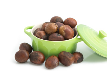 roasted chestnuts in green bowl on white background
