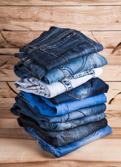 fashionable clothes. pile of jeans on a wooden background