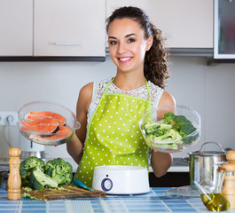 Girl preparing fish and veggies