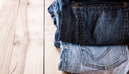 fashionable clothes. pile of jeans on a wooden background