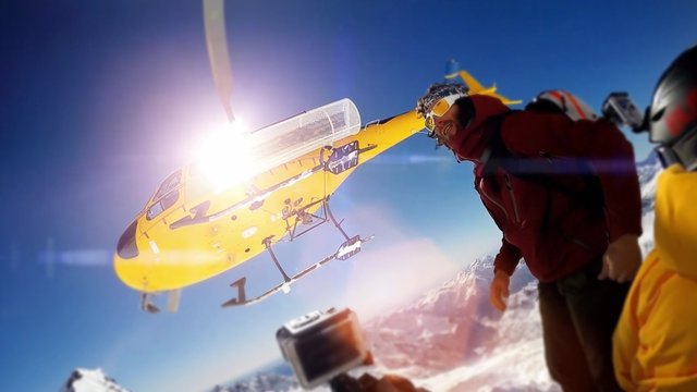 Heli boarding, Heli skiing in den Alpen - Hubschrauber setzt Sportler auf Berggipfel ab und fliegt los