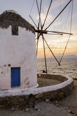 Windmill in Chora,Mykonos,Greece at sunset.Traditional greek island whitewashed architecture,popular landmark,tourist destination against colourful sky and Aegean sea.The wind mills are now decorative © f8grapher