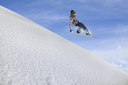 Flying snowboarder on mountains