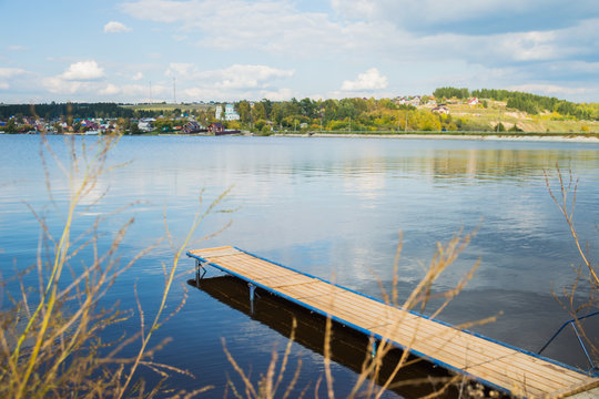 Пейзаж у реки с изображением деревянного  пирса 