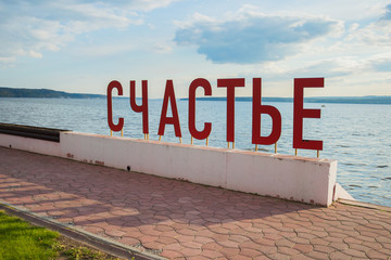 Набережная реки с надписью "счастье здесь" на русском языке