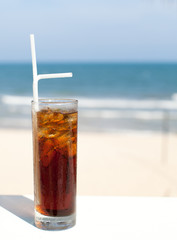 Iced soda drink in a glass on sea background