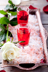 Rose flavor liqueur in shot glasses on pink salt