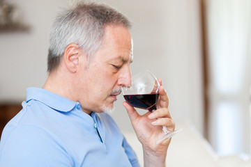 Mature man enjoying a glass of red wine
