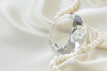 large glass diamond and pearl necklace on a soft silk background