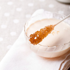 Glass cup with yogurt and cane sugar crystals