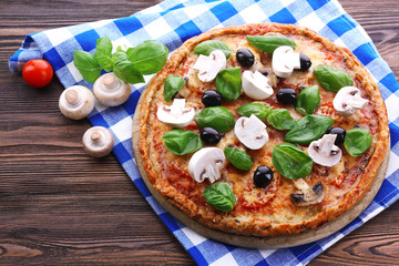 Tasty pizza with vegetables and basil on table close up