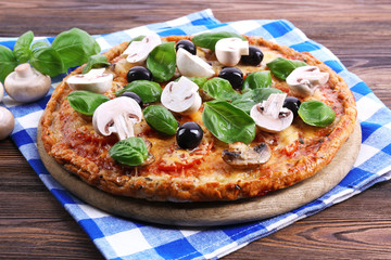 Tasty pizza with vegetables and basil on table close up