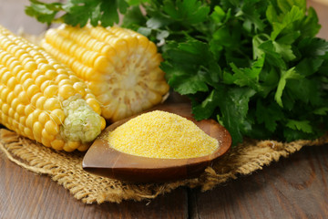 Natural organic corn grits and cobs on the wooden table - obrazy, fototapety, plakaty