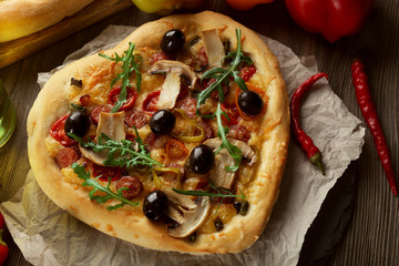 Heart shaped pizza on craft paper on wooden table