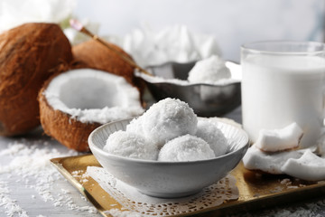 Homemade Candies in coconut flakes and fresh coconut on light background