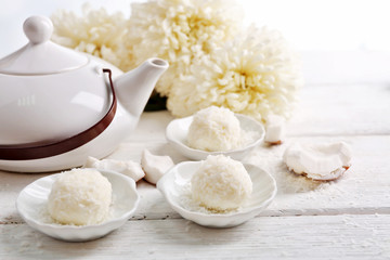 Homemade coco sweets on plate, on light background