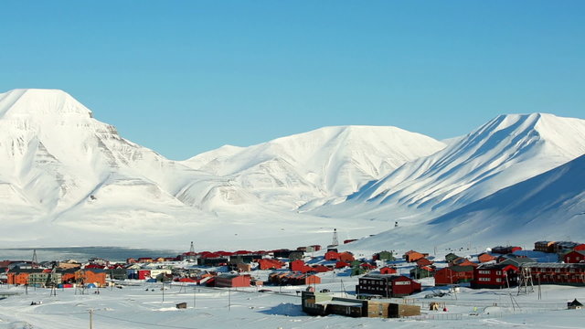 Small town Longyearbyen among snow-capped mountains of the Norwegian archipelago of Svalbard in early spring.