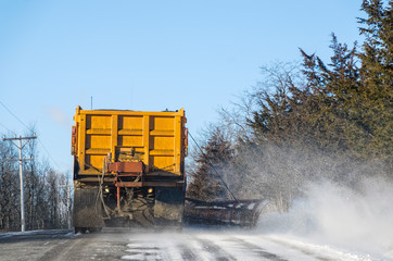 Large Snowplow Cleaning Up the Last of a Snowfall on the Road