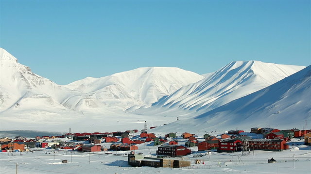 Small town Longyearbyen among snow-capped mountains of the Norwegian archipelago of Svalbard in early spring.