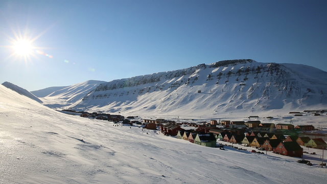 Small town Longyearbyen among snow-capped mountains of the Norwegian archipelago of Svalbard in early spring.