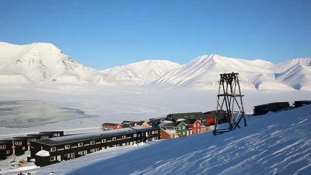 Small town Longyearbyen among snow-capped mountains of the Norwegian archipelago of Svalbard in early spring.