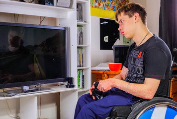 Handicapped boy plays in his room video games