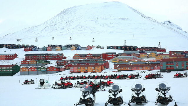 Many snowmobiles on the background of a small town in the far North. Longyearbyen, Svalbard, Norway.