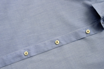 Shirt clothing closeup.Light blue shirt with buttons as a background pattern.